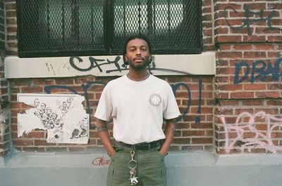 Full length of young man standing against wall