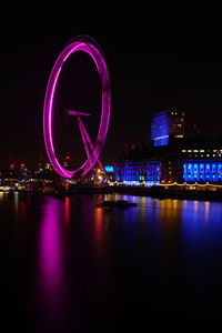 Illuminated bridge over river at night