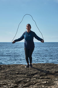 Full length of young woman standing on beach