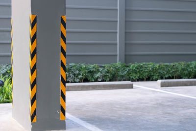 Close-up of yellow flag on road against wall