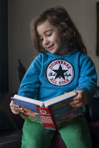 Cute girl holding smart phone at home