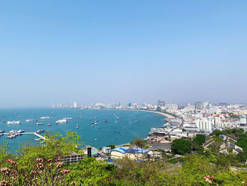 High angle view of buildings and sea against clear sky