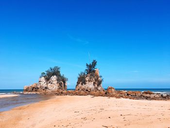 Scenic view of beach against blue sky