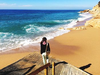 Full length of man standing on beach against sky