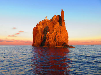 Rock formation in sea against sky