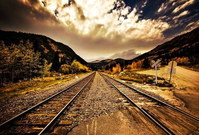 Railroad tracks against sky during sunset