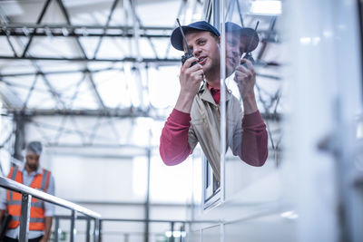 Worker with walkie-talkie instructing in factory