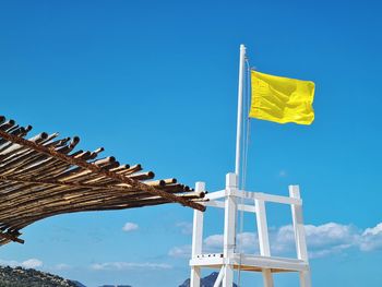 Low angle view of flag against blue sky