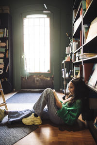 Girl reading book while sitting in bookstore