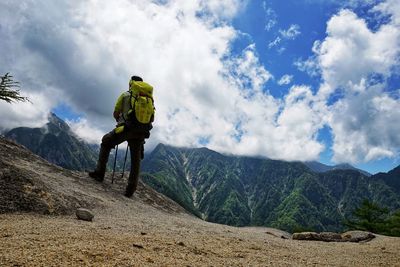 Rear view of man hiking on mountains