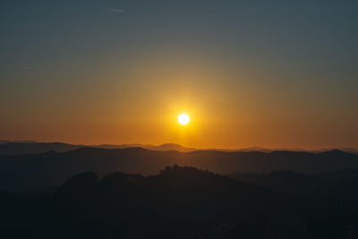 Scenic view of silhouette mountains against sky during sunset