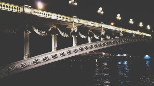 Low angle view of illuminated bridge against sky at night