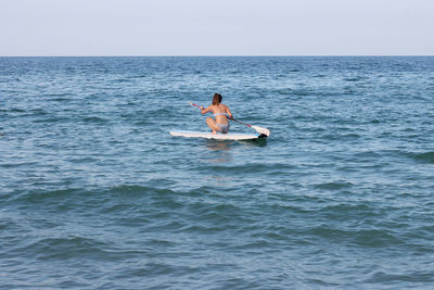 Woman on surf in the sea against sky