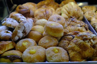 Italian pastries croissants and zeppole, deep-fried dough ball topped with sugar filled with custard