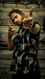 Young man holding camera while standing outdoors