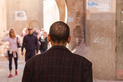 Rear view of people standing against building