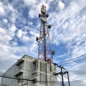 Low angle view of communication tower on building against sky