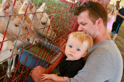 Portrait of son with father by fence in zoo