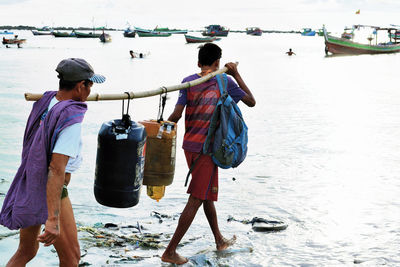 Rear view of people standing on beach