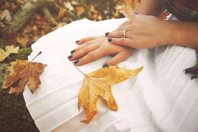 Close-up of woman hand with autumn leaves
