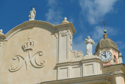 Low angle view of statue against building against sky