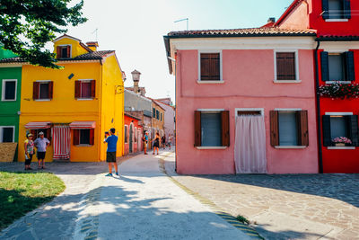 Street amidst houses and buildings in city against sky