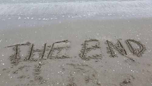 High angle view of text on sand at beach