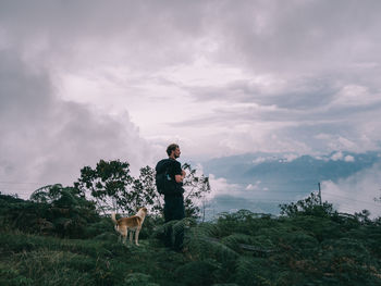 Full length of man standing on mountain against sky