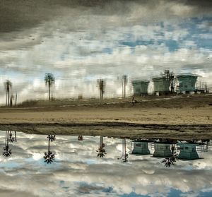 View of field against cloudy sky