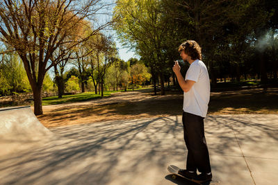 Full length of man photographing while standing on tree