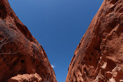 Low angle view of rock formation against clear blue sky