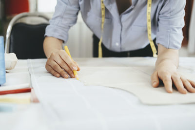 Closeup young tailor working with sewing pattern