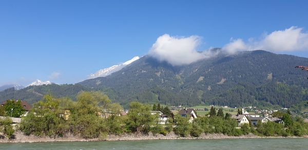 Scenic view of lake by mountains against sky