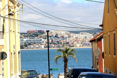 Buildings by sea against sky in city