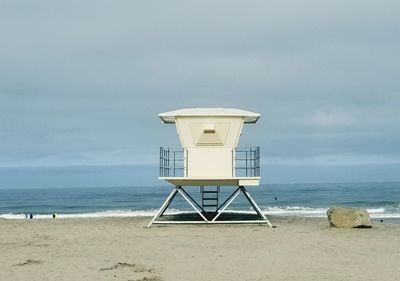 Lifeguard hut on beach against sky