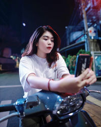 Young woman looking at camera while sitting in bus