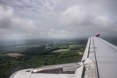 Airplane flying over landscape against sky
