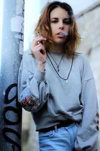 Young woman smoking outdoors