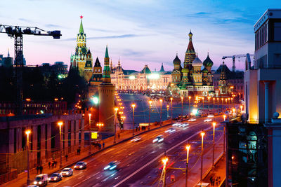 Illuminated city street and buildings at night