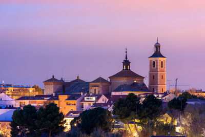 Illuminated buildings in city at dusk