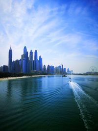 View of buildings by sea against sky