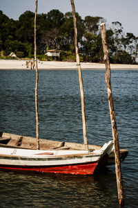 Sailboats moored in sea against sky