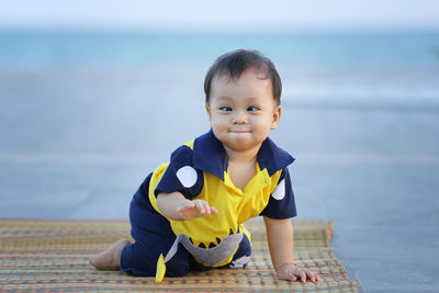 Portrait of cute boy on beach against sea