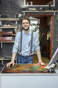 Portrait of smiling man standing at table