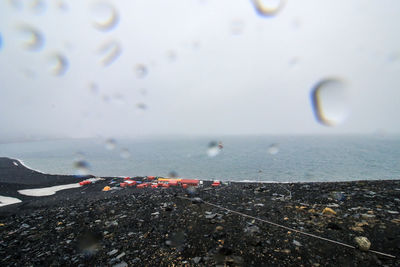 Close-up of water drops on sea against sky