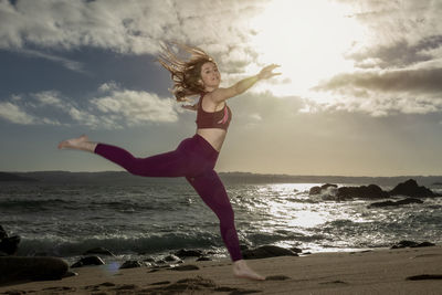 Woman in sportswear jumping on the beach