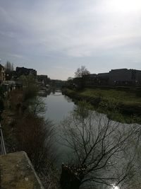 Scenic view of river by buildings against sky