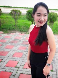 Portrait of smiling young woman standing outdoors