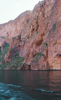 Rock formations by sea against sky