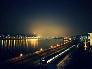 Illuminated bridge in city against sky at night